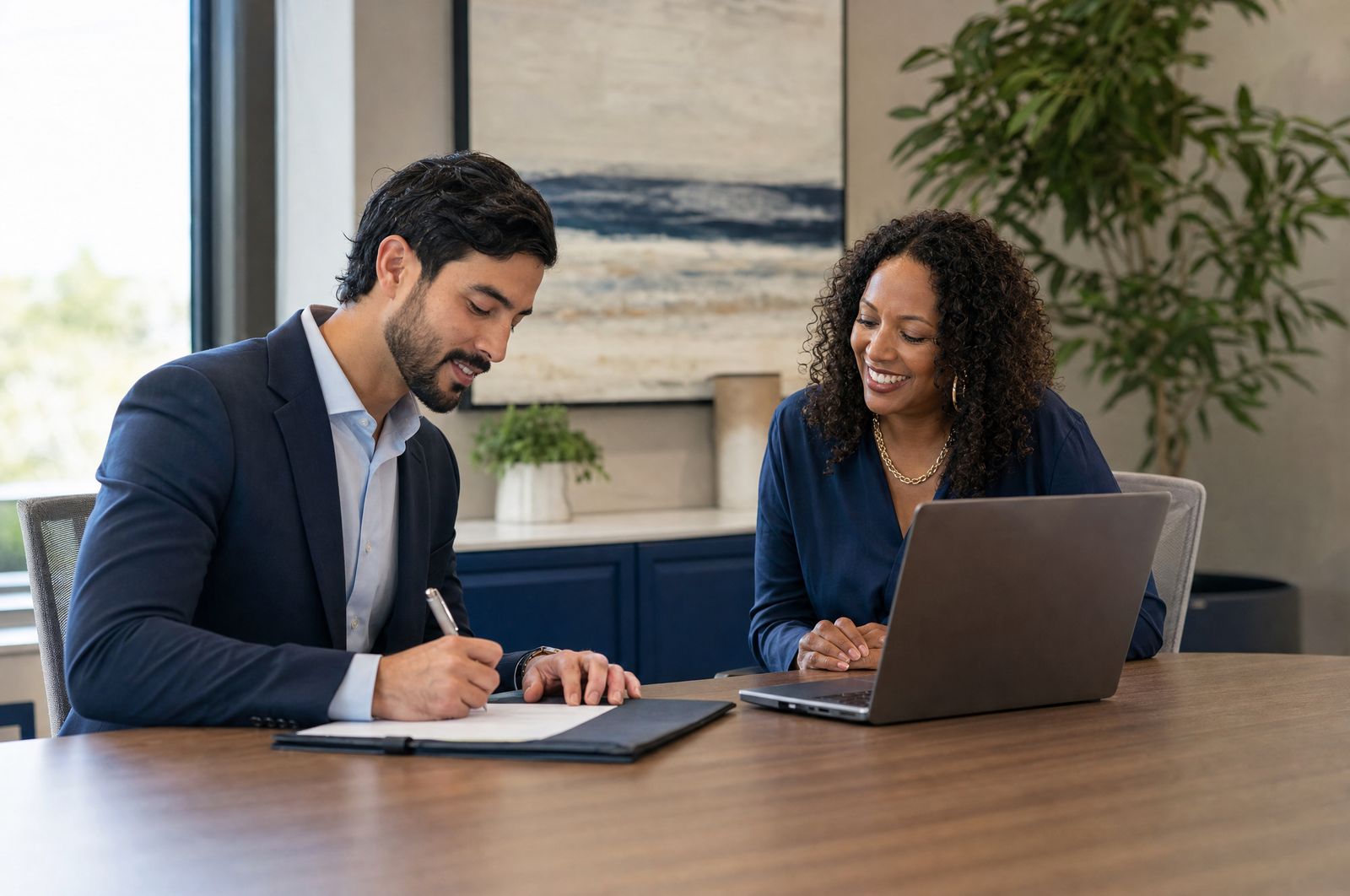 A new physician signing onboarding paperwork with an office manager